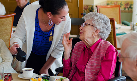 elder woman being served coffee