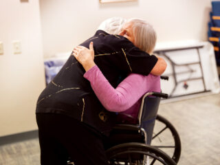 MaryAnn embraces a resident with compassion at Redeemer Health and Rehab, reflecting her legacy of love and service.
