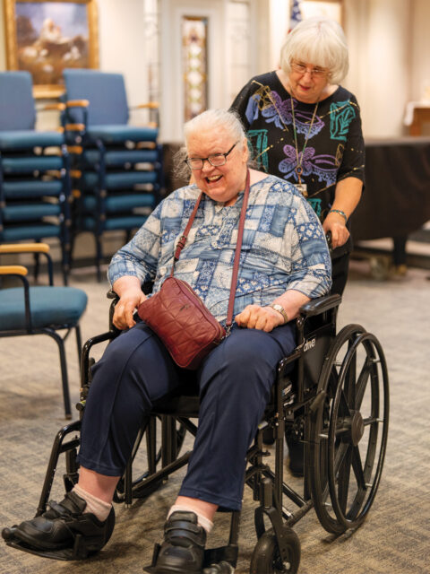 MaryAnn, part-time chaplain at Redeemer Health and Rehab, joyfully supports a resident during a community activity.